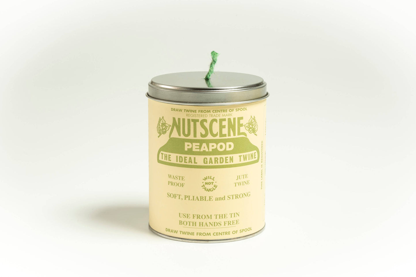 Eine Dose Nutscene Twines Ltd – Kultige Dose Nutscene Twine (490 Fuß) mit grünem Garn, das aus dem Deckel herausragt. Das Etikett betont das abfallfreie, dreilagige Jutegarn und betont, dass es weich, biegsam und robust ist.