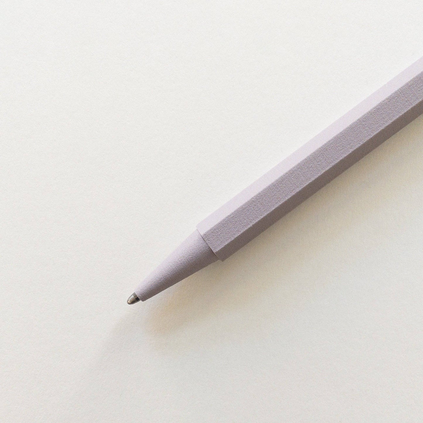 Eine Nahaufnahme des Prototo - Zero Waste Kugelschreibers in Lavendel, gebrandet von Prototo, liegt schräg auf einem leeren weißen Blatt - sein elegantes Design macht nachhaltiges Schreiben stilvoll.