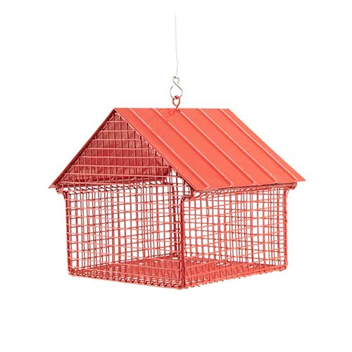 Der Erdnuss Futterspender Häuschen | Rot von Wildlife Garden, ein rotes Erdnusshäuschen aus Draht mit einem Metalldach, hängt an einem Haken vor einem weißen Hintergrund.