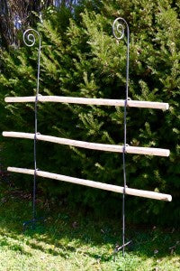 Die Hase und Hirsch "Bischofstab mit Knoten mit Holz im SET 5-tlg." Rankhilfe, mit Holzstangen (150 cm) und einem Knotenstab (170 cm), steht elegant auf Gras vor üppig grünen Büschen.