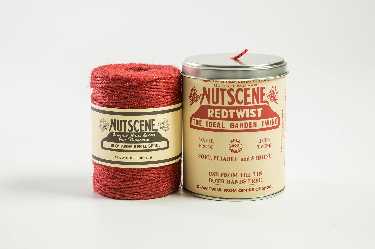 Eine Spule mit rotem Bindfaden von Nutscene Twines Ltd und eine dazu passende, ikonische Dose mit der Aufschrift „Nutscene Twine – Schnur in einer Dose (490 Fuß)“, beide vor einem weißen Hintergrund.