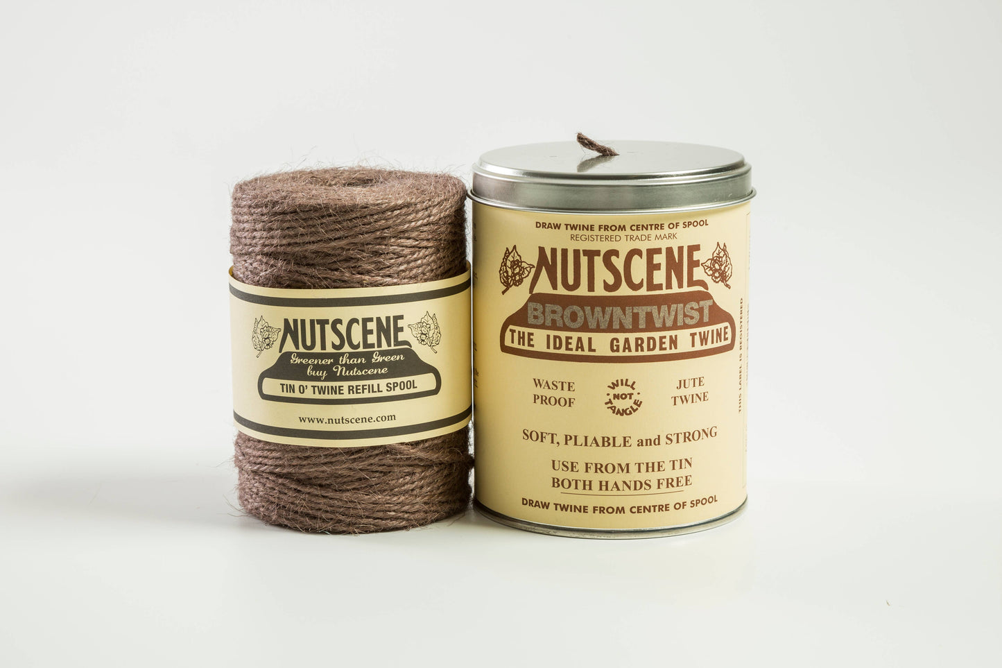Eine Spule braunes Jutegarn von Nutscene Twines Ltd liegt neben einer ikonischen Dose Nutscene Twine (490 Fuß) von Nutscene Twines Ltd, beide auf weißem Hintergrund.