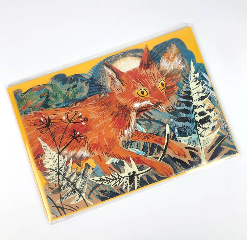 Eine lebendige Illustration von Mark Hearld zeigt einen roten Fuchs mit gelben Augen zwischen Farnen und wilden Pflanzen, unter dem Mond in einem blau-gelben Himmel - zu sehen auf der Fuchs Collage Karte von Mark Hearld von Art Angels.