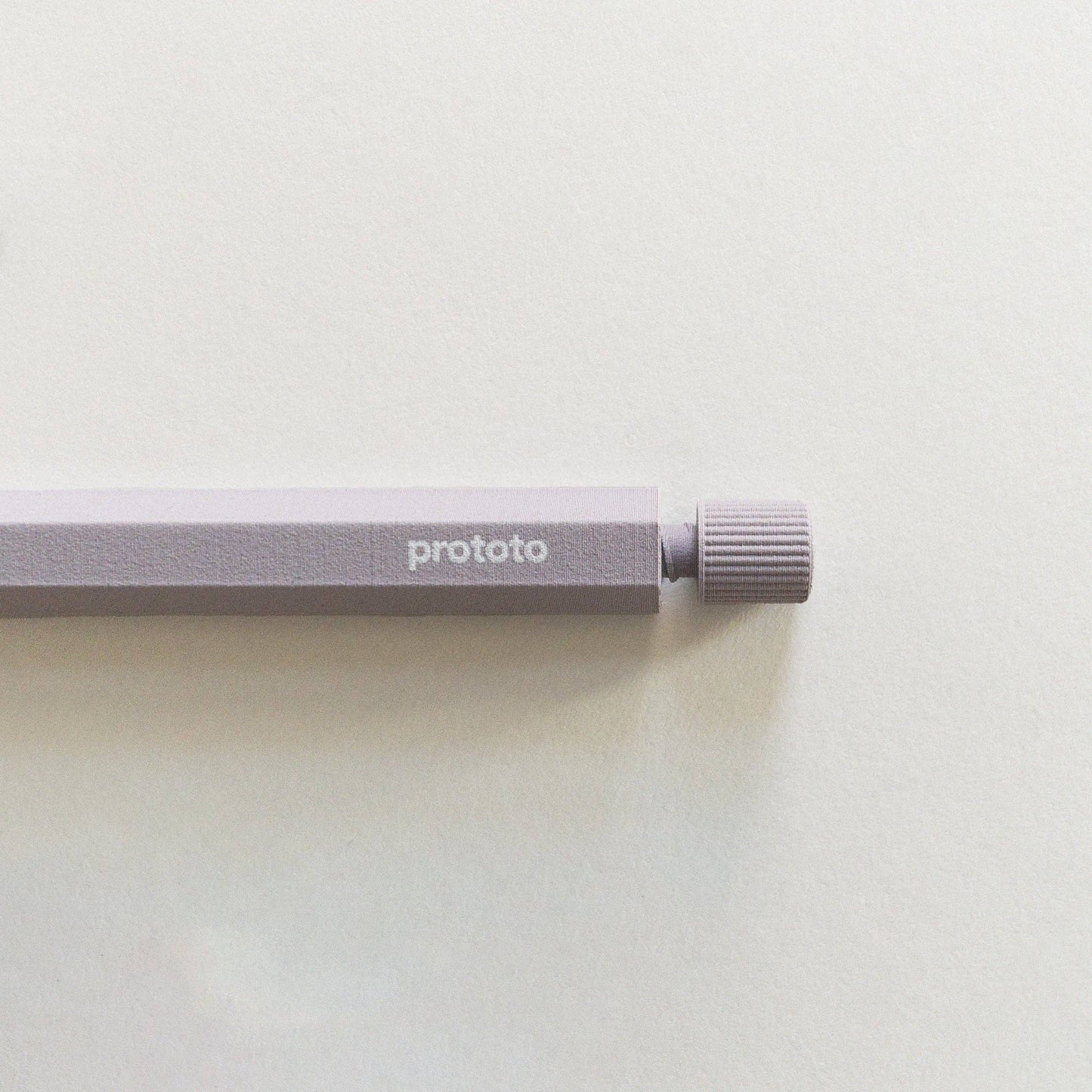 Eine Nahaufnahme des Prototo Zero Waste Kugelschreibers in Lavendel, mit dem Prototo-Markennamen an der Seite, der auf einer leicht strukturierten Oberfläche ruht - eine ideale Wahl für alle, die umweltfreundliche Schreibwaren suchen.