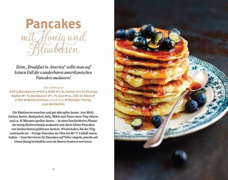 Ein Stapel Pfannkuchen mit Blaubeeren und Honig liegt auf einem dekorativen Teller. Links steht in schwarz-orangefarbener Schrift „New York süße Klassiker“ vom Thorbecke Verlag und weckt so die klassische Brunch-Stimmung des Big Apple.