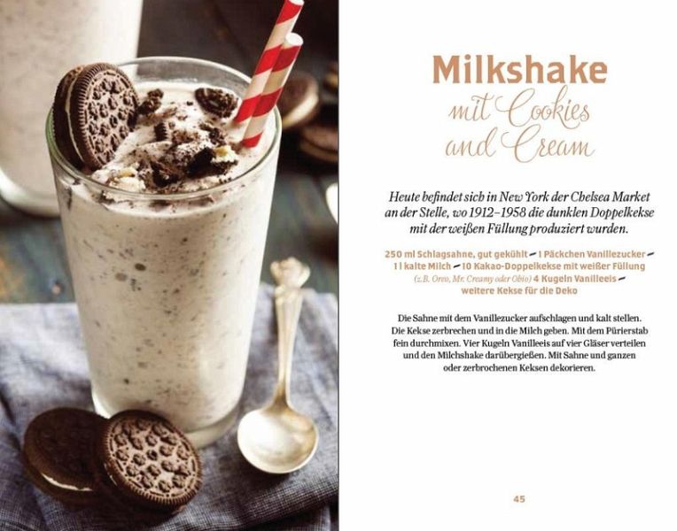 Ein Glas Cookies-and-Cream-Milchshake mit Schlagsahne und Schokoladenkeksen steht neben zusätzlichen Keksen und dem Rezeptbuch „New York süße Klassiker“ vom Thorbecke Verlag.