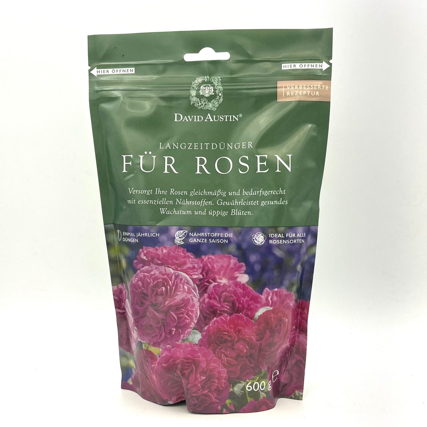 Ein 600g-Beutel David Austin - Langzeitdünger für Rosen besticht durch seine grüne Verpackung mit rosa Rosen und deutschem Text, der für eine gesunde Wurzelentwicklung und lebendige Rosenblüten wirbt.
