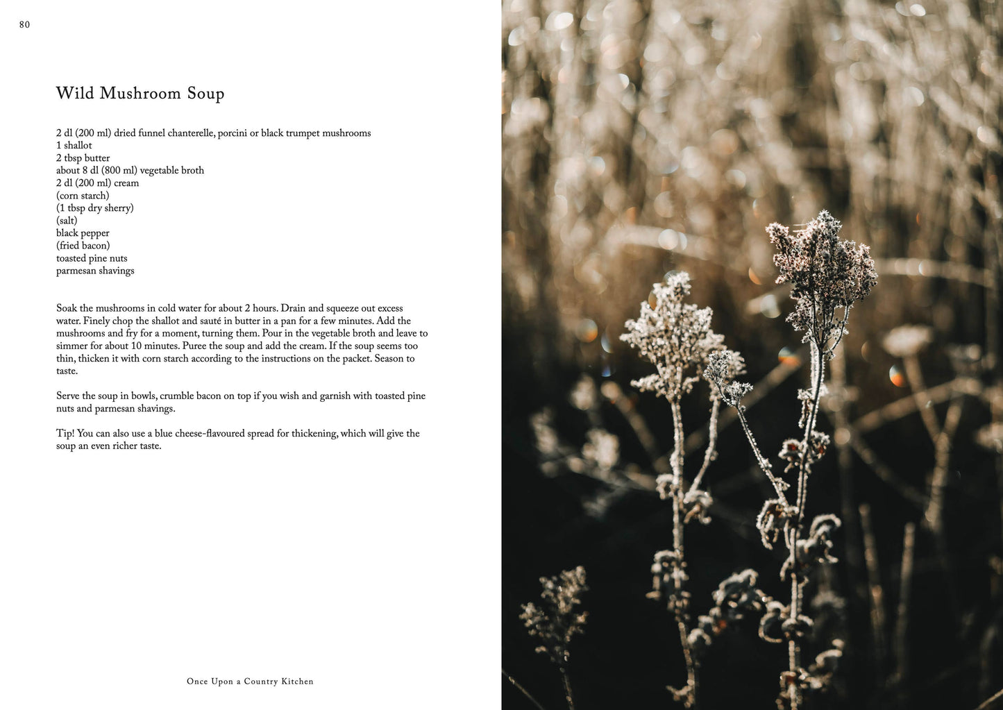 Das Kochbuch „Once upon a country kitchen“ von Cozy Publishing enthält ein Rezept für eine Wildpilzsuppe neben einem Foto getrockneter Wildblumen auf einem unscharfen natürlichen Hintergrund und fängt den rustikalen Charme und die Reinheit der Zutaten in elegantem Schwarz-auf-Weiß-Text ein.
