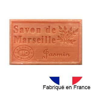 Ein rechteckiges Stück Dampa 1975 - Marseiller Seife mit Bio-Olivenöl-Jasmin-Duft, mit der Aufschrift "Savon de Marseille Jasmin" und einem Blattmuster. Unterhalb der Seife sind eine französische Flagge und "Fabriqué en France" zu sehen.