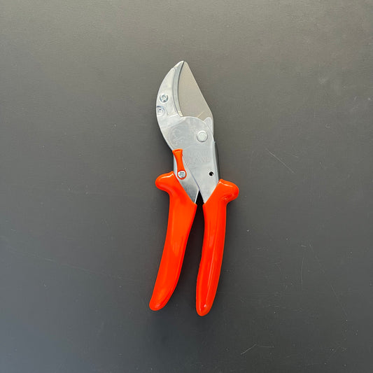 Eine Gartenschere vom Typ Löwe Original Löwe 10 – mit leuchtend orangefarbenen Griffen und einer silbernen Klinge auf dunklem, einfarbigem Hintergrund.