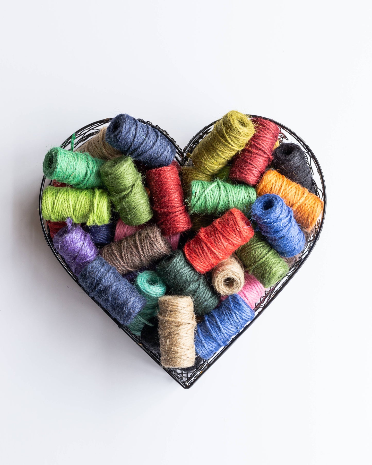 Ein herzförmiger Behälter enthält ein 3er-Pack Nutscene Twines Ltd Mini Reels of Twine, jedes 42 Fuß lang, auf weißem Hintergrund - ideal für kreative Projekte und Bastelspaß.