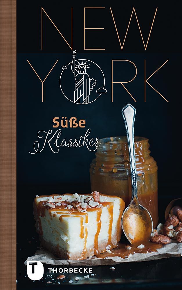 Cover des Buches „New York süße Klassiker“ vom Thorbecke Verlag mit einem reichhaltigen Käsekuchen mit Karamell und Nüssen, einem Glas Karamellsauce, einem Löffel und dem Umriss der Freiheitsstatue über dem Titel.