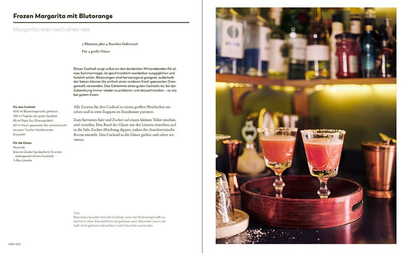 Die linke Seite zeigt ein deutsches Rezept für eine Frozen Margarita mit Blutorange. Die rechte Seite zeigt zwei rosafarbene Cocktails mit gewürzgesalzenen Rändern und getrockneten Zitrusfrüchten auf einem Tablett mit dem Bargeschirr Meersalz | Meistern Sie die Kunst des perfekten Würzens des Ars Vivendi Verlags im Hintergrund.