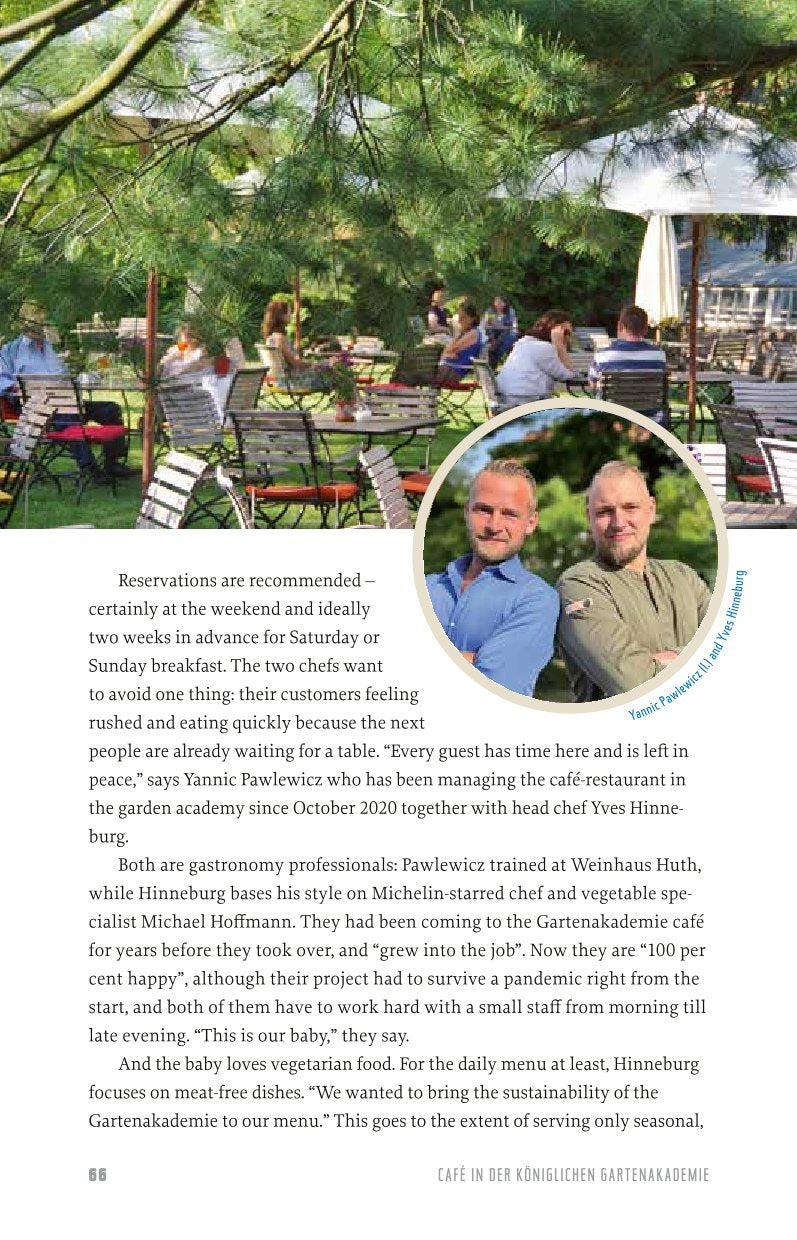 Zwei Köche lächeln vor den Bäumen eines beliebten Berliner Freiluftrestaurants zusammen, hinter ihnen sonnenbeschienene Tische und Gäste. Ein blaues Etikett nennt den Namen des Kochs rechts. Aus "Urbane Oasen in Berlin" vom Bebra Verlag.