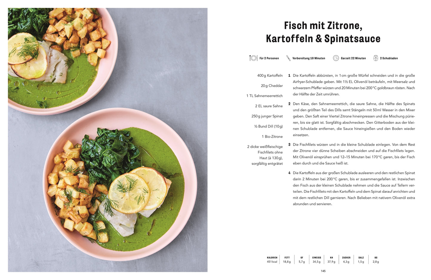 Auf zwei rosafarbenen Tellern liegen weiße Fischfilets mit Zitrone, knusprige Kartoffelwürfel aus der Easy Air Fryer des DK Verlags, sautierter Spinat und grüne Soße auf einem hellen Hintergrund neben einer deutschen Jamie Oliver Kochbuch-Rezeptseite.