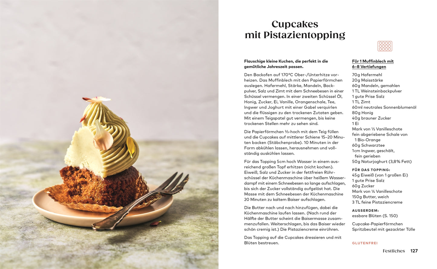 Ein aufgeschnittener Cupcake mit grüner Pistazienglasur und Nüssen liegt auf einem Teller mit einer Gabel. Daneben steht "Kleine Kuchen | 50 Rezepte für Mini-Kuchen, kleine Torten & mehr" vom DK Verlag. Der Hintergrund ist sanft verschwommen.