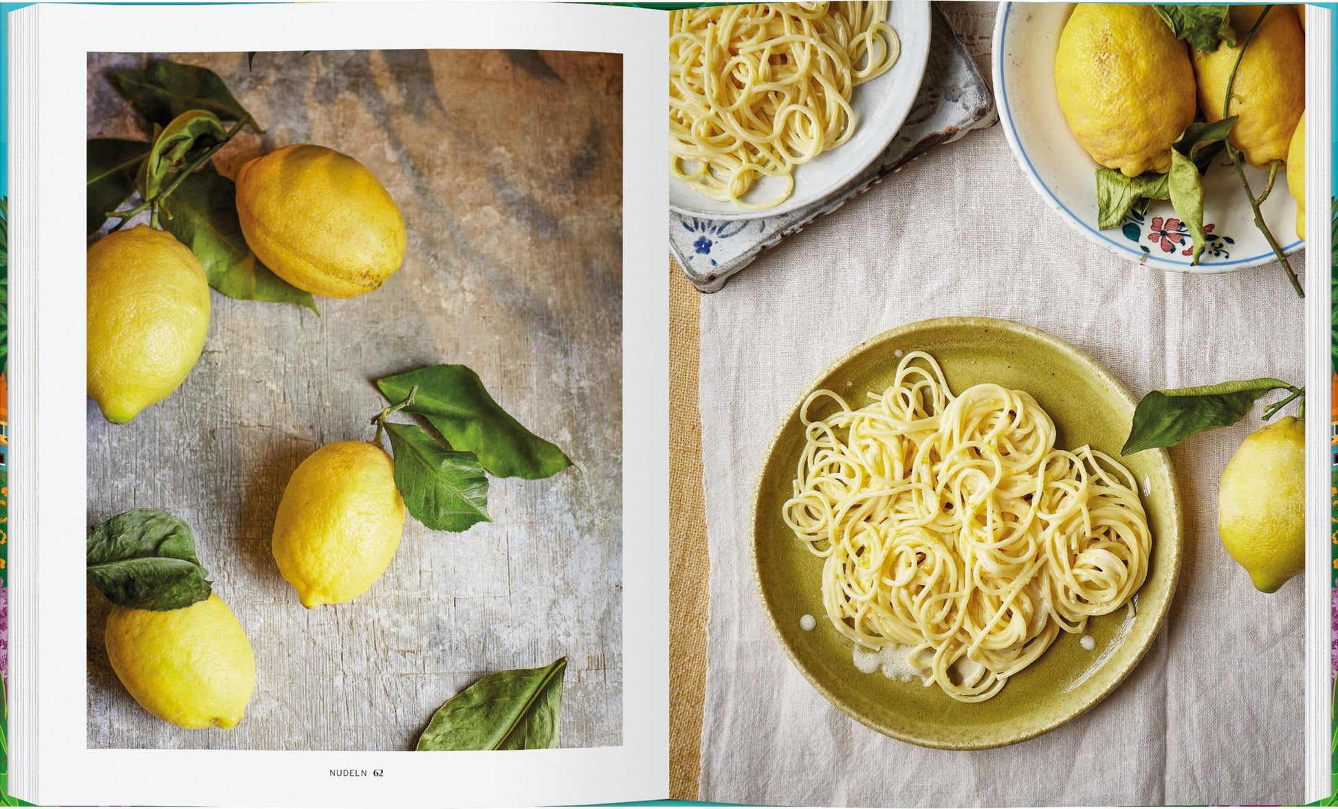 Ein aufgeschlagenes Exemplar von „Die Küche von Amalfi“ vom Gerstenberg Verlag zeigt frische Zitronen mit Blättern und Teller mit Zitronennudeln – ideale Inspiration für authentische Rezepte aus der italienischen Küche.
