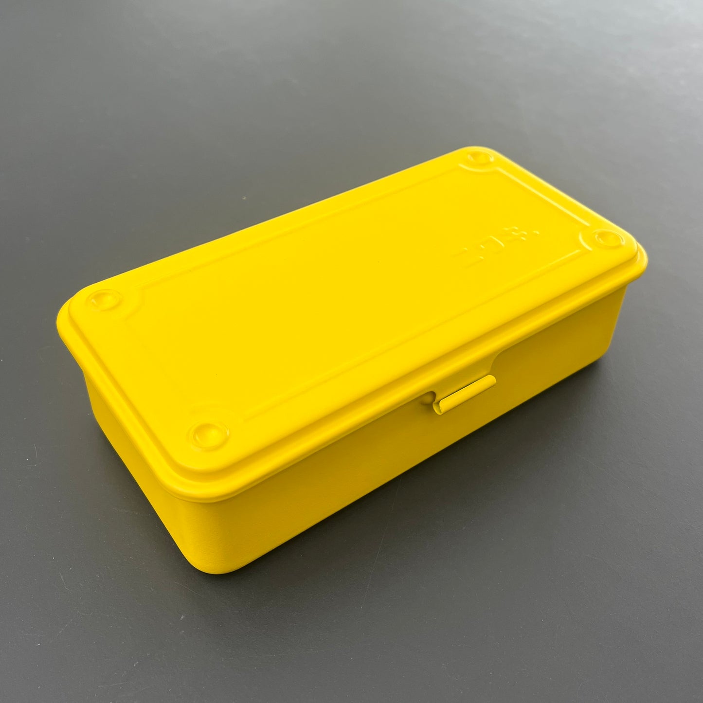 Die Niwaki T-Type Toolbox ist eine rechteckige gelbe Box mit abgerundeten Ecken und einem Frontriegel, perfekt als Werkzeugbox für Gärtner und Handwerker.
