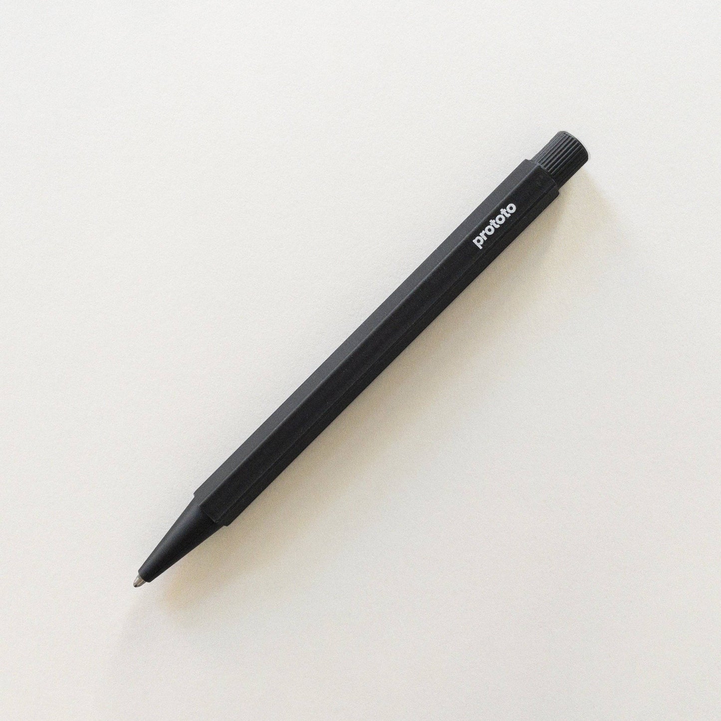 Ein Prototo – Zero Waste Kugelschreiber in Schwarz von Prototo, hergestellt aus erdölfreiem Bioplastik mit „Proto“ auf der Seite, ist diagonal auf einem schlichten weißen Hintergrund abgebildet.