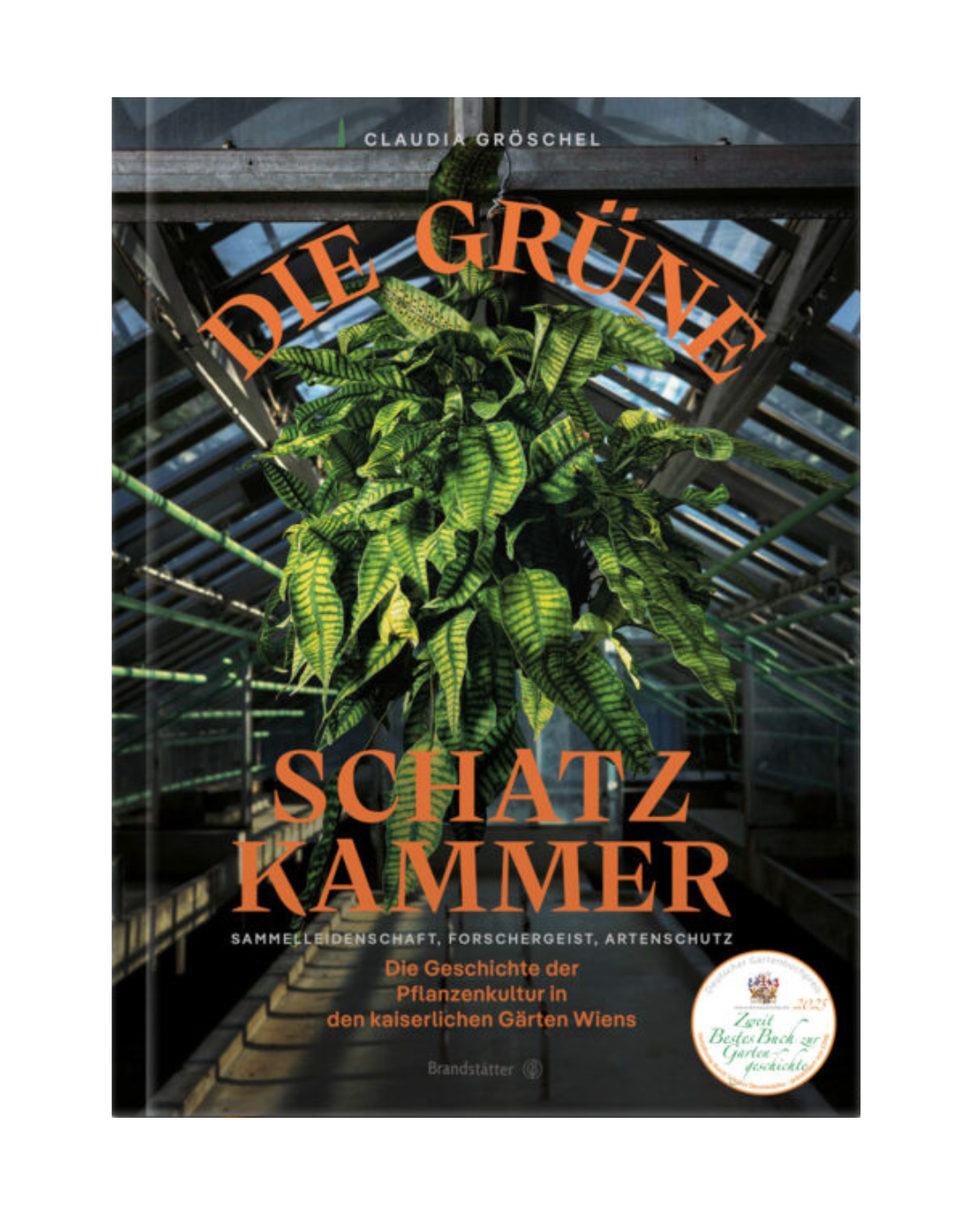 Das Buchcover von Die grüne Schatzkammer aus dem Brandstätter Verlag zeigt einen leuchtend grünen Farn in einem gläsernen Gewächshaus im Schlosspark Schönbrunn, mit fettgedruckter gelber Schrift und einem runden Preisaufkleber in der rechten unteren Ecke.