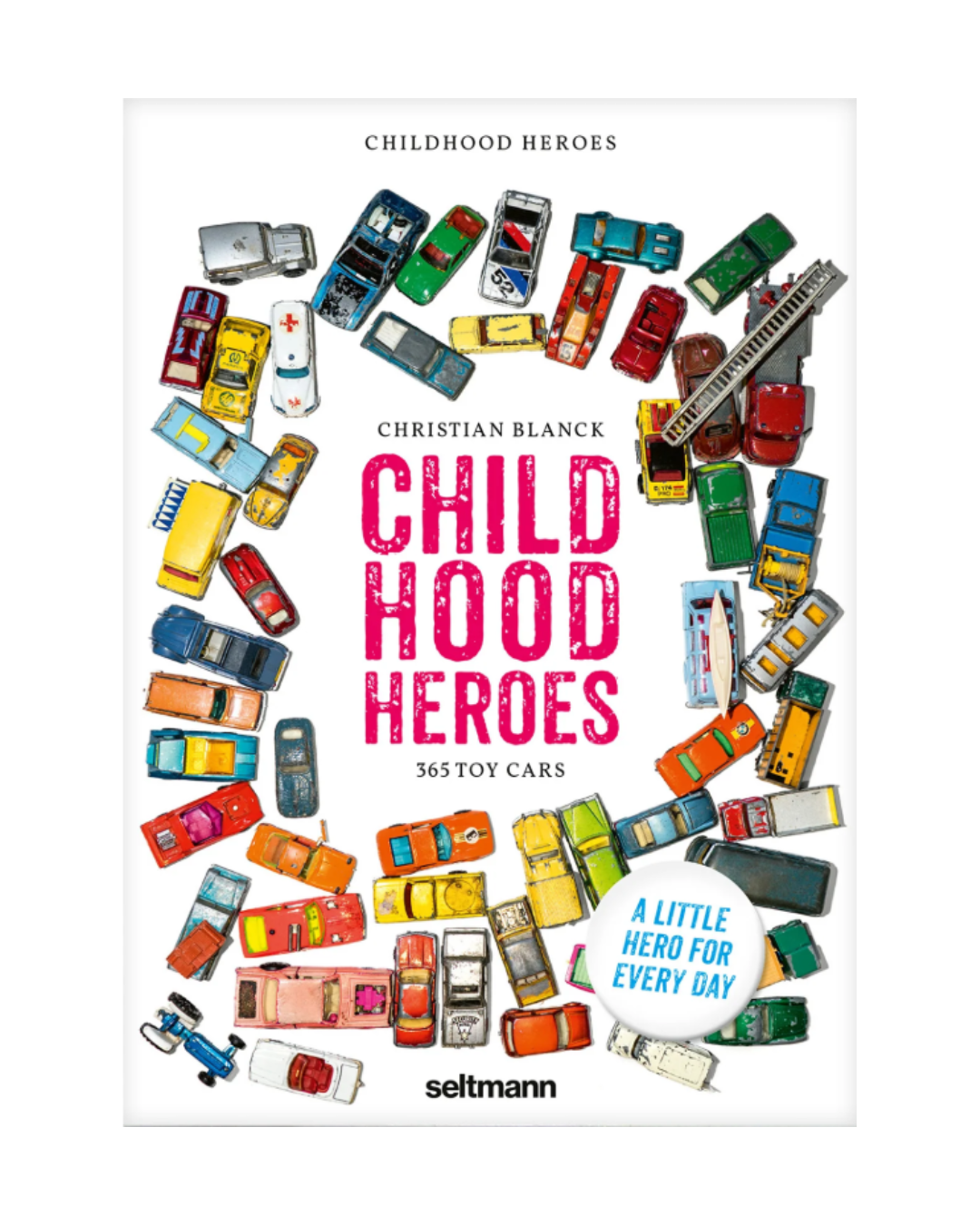 Das Cover des Kinderzimmerhelden Abreißkalenders vom Seltmann Verlag zeigt bunte Spielzeugautos in einem Kreis um den fetten rosa Titel auf weißem Grund, der an Nostalgie erinnert. Auf einem blauen Aufkleber steht "Ein kleiner Held für jeden Tag".