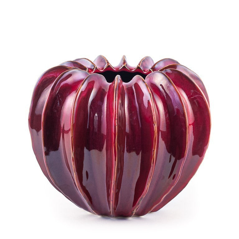 Die Des Pots Vase | Bordeaux skulpturale Form L setzt mit ihrem glänzenden, tiefroten Finish und dem runden, gerippten Design, das an einen Kürbis erinnert, einen eleganten Akzent vor jedem weißen Hintergrund.