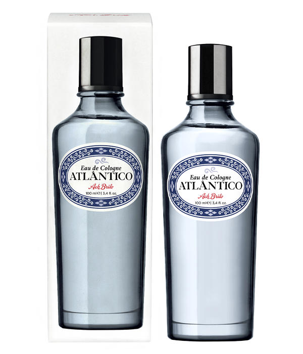 Zwei Ach.Brito - Eau de Cologne - Atlântico 100 ml Glasflaschen mit Metallkappen: eine verpackt, eine nicht verpackt. Beide haben blaue und weiße Etiketten mit roten Textakzenten und bieten einen erfrischenden Duft.