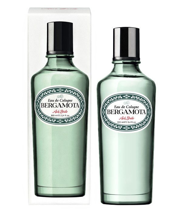 Zwei klare grüne Glasflaschen von Ach.Brito - Eau de Cologne - Bergamota 100 ml, mit silbernen Verschlüssen und dekorativen Etiketten in Schwarz und Rot, stehen neben einer weißen Schachtel mit passendem Design und vermitteln einen erfrischenden Duft.