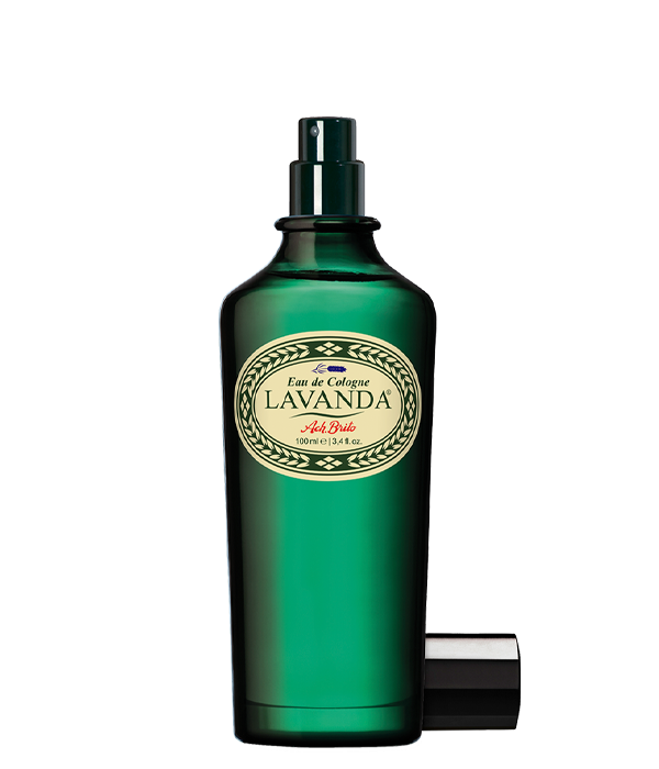 Ein grüner Glasflakon von Ach.Brito - Eau de Cologne - Lavander 100 ml mit beigem Etikett und Sprühkopf, daneben die schwarze Kappe auf weißem Grund, verkörpert den klassischen Lavendelduft.