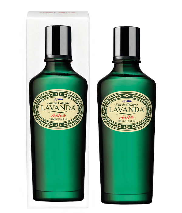 Zwei grüne Glasflaschen von Ach.Brito - Eau de Cologne - Lavander 100 ml, jeweils mit cremefarbenem und goldenem Etikett, stehen vor einem klaren Verpackungskarton auf strahlend weißem Hintergrund und fangen den erfrischenden Duft von Lavendel ein.