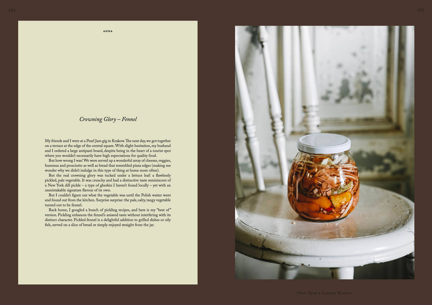 Das Kochbuch „Once upon a country kitchen“ von Cozy Publishing enthält reines, geschichtetes fermentiertes Gemüse in einem Glasgefäß, das auf einem rustikalen weißen Stuhl neben einer Landhausküchenwand präsentiert wird, wobei Fenchel und Rezeptnotizen auf der linken Seite hervorgehoben sind.