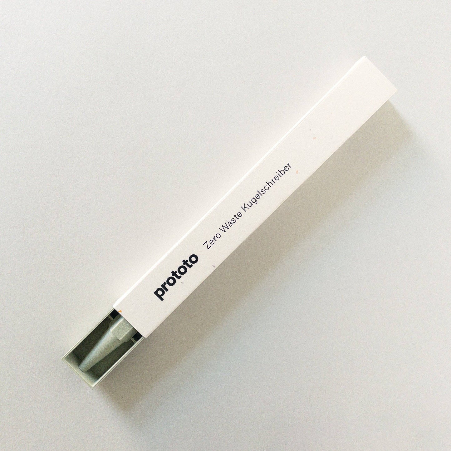 Eine weiße rechteckige Box mit der Aufschrift „Prototo – Zero Waste Kugelschreiber in Salbei“ von Prototo, in deren Inneren teilweise ein klimaneutraler Stift aus Biokunststoff sichtbar ist, platziert auf einem schlichten weißen Hintergrund.