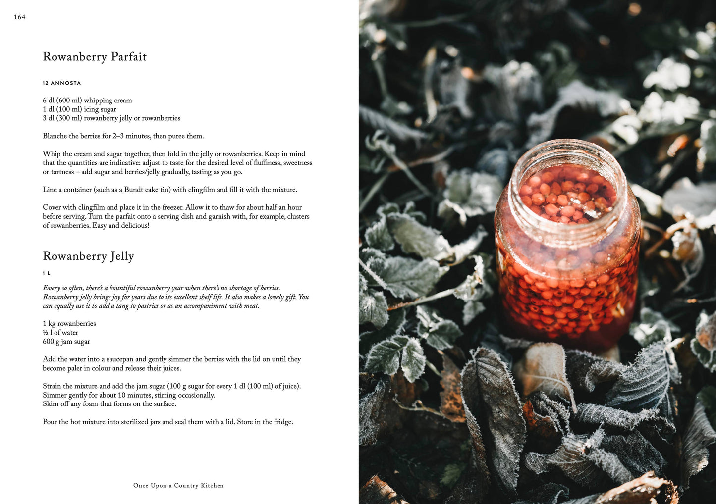 Ein Glas mit roten Vogelbeeren steht zwischen frostigen Blättern und vermittelt rustikale Reinheit. Das Bild zeigt Rezepte für Vogelbeerparfait und -gelee aus dem Kochbuch „Once upon a country kitchen“ von Cozy Publishing.