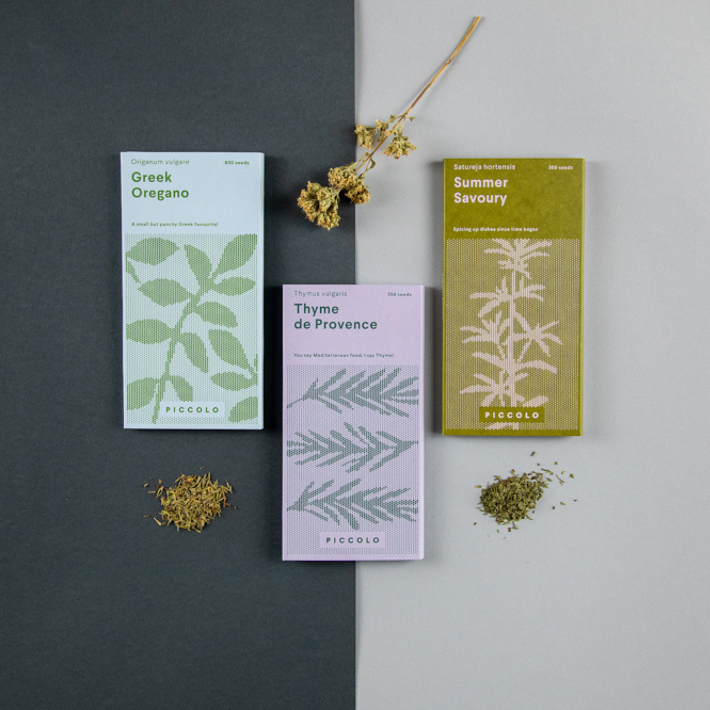 Drei illustrierte Päckchen „Kräuter der Provence“ von Piccolo Seeds – Griechischer Oregano, Thymian der Provence und Bohnenkraut – sind auf einem geteilten Hintergrund mit verstreuten getrockneten Kräutern und einem Zweig angeordnet und erinnern so an die klassischen Kräuter der Provence.