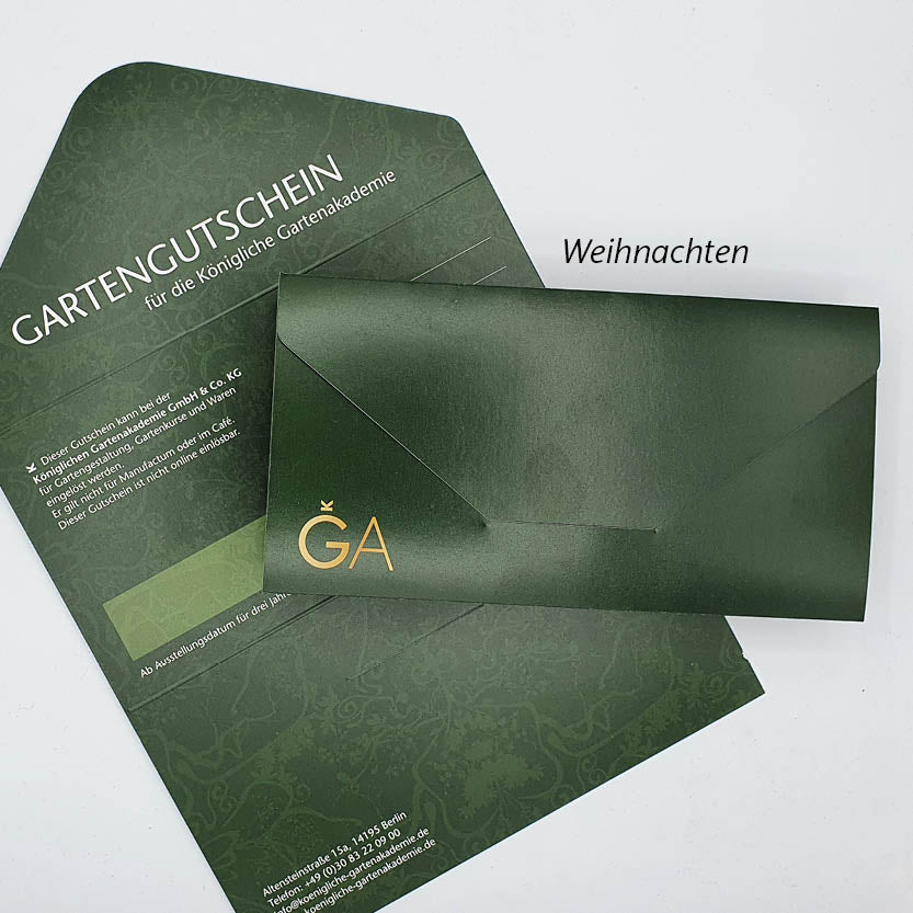 Aus einem passenden Umschlag lugt ein grüner Gutschein für die Königliche Gartenakademie mit goldenen GA-Initialen hervor. „Weihnachten“ oben macht es zum perfekten Weihnachtsgeschenk für Fans der Königlichen Gartenakademie oder Ihrer Lieblingsgärtnerei.