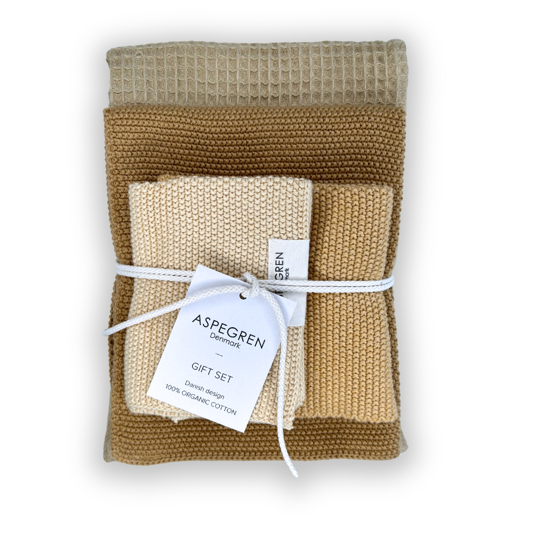 Entdecken Sie das Aspegren Denmark Geschenkset Melone: drei gefaltete Geschirrtücher aus 100% Bio-Baumwolle in den Farben beige, braun und hellbraun, gebunden mit weißer Schnur. Nachhaltig und perfekt als Küchen- oder Reinigungstücher.
