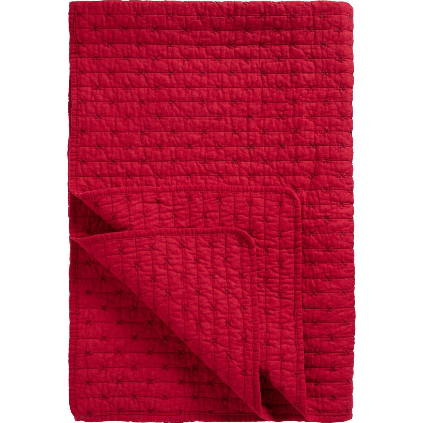 Eine gefaltete rote Ib Laursen | Quilt Decke rot mit Kreuzstich von IB Laursen, mit abgestepptem Gittermuster und umgedrehter Ecke, ideal als gemütliche skandinavische Wohndecke für stilvolle Wohnräume.