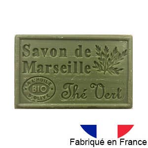 Ein grüner Dampa 1975 Marseille-Seife Riegel mit Grüntee-Duft, hergestellt mit Bio-Olivenöl. Zeigt einen Olivenzweig und „à l'huile bio d'olive“ sowie eine französische Flagge und „Fabriqué en France“. Von Dampa 1975 – mit Bio-Olivenöl & grünem Tee.