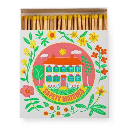 The Archivist Gallery - Zuhause von Ariane Butto Quadrat-Sicherheitsstreichhölzer mit gelben Streichhölzern in einer Schachtel mit einem alten Haus, Blumen und Blättern - ideal als neues Zuhause Geschenk. Auf der Unterseite steht "SAFETY MATCHES".