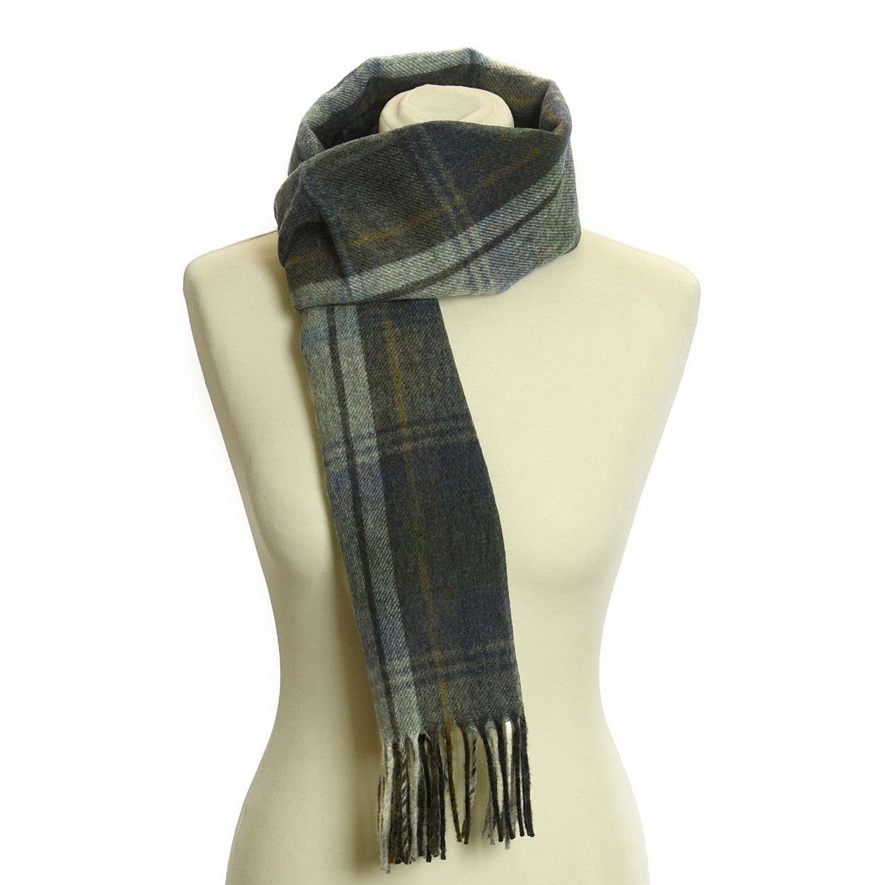 Ein Lammwoll-Landkaro-Schal von Tweedmill Textiles mit Fransenenden in grünem, blauem und grauem Tartan ist um den Hals eines cremefarbenen Mannequin-Torsos drapiert. Hergestellt aus 100% Lammwolle von Tweedmill Textiles.