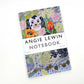 Das Art Angels - Wally Dogs and Tulpen Notizbuch von Angie Lewin zeichnet sich durch ein floral-geometrisches Cover mit einem stilisierten schwarz-weißen Hund aus, der auf weißem Hintergrund beschriftet und dargestellt ist.