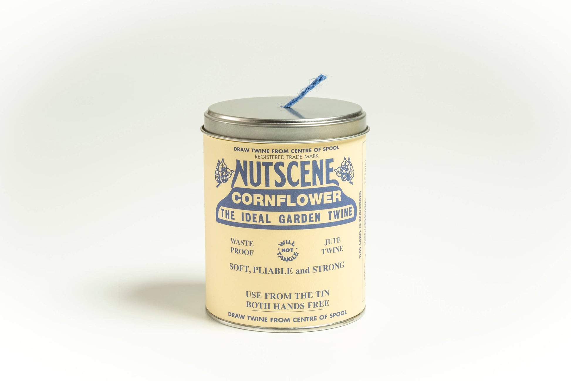 Eine zylindrische Dose mit der Aufschrift „Nutscene Twines Ltd – Iconic Tin of Nutscene Twine – Schnur in einer Dose (490 Fuß)“ mit blauem Text und 3-lagigem Jutegarn, das aus einem Metalldeckel auf einem schlichten weißen Hintergrund herausragt.