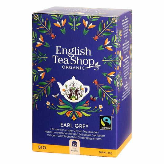 Eine blaue Schachtel English Tea Shop – Earl Grey, BIO Fairtrade (20 Teebeutel) zeigt farbenfrohe Blumenmuster, eine weiße Teekannenabbildung und zeigt Fairtrade- und Bio-Zertifizierungssiegel.