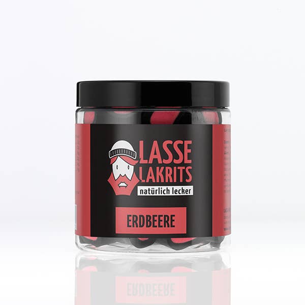 Ein durchsichtiges Plastikgefäß mit schwarzem Deckel enthält LASSE LAKRITS - natürlich lecker - Dose Lakritz Erdbeere Bonbons. Das Etikett zeigt die Marke LASSE LAKRITS und ein Cartoon-Gesicht - authentisches schwedisches Lakritz mit Erdbeergeschmack.