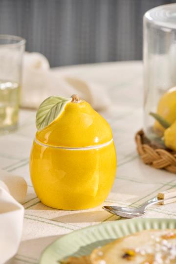 Die "Dose mit Deckel | Zitrone" von IB Laursen ist ein charmantes Zitronenglas aus Keramik mit blattförmigem Deckel, das ideal ist, um Ihre Küche oder Ihren Tisch zu verschönern.