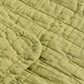 Nahaufnahme der IB Laursen Steppdecke hellgrün mit Kreuzstich-hellgrüner Steppstoff mit sichtbarem Kreuzstich und abgerundeten Kanten, der eine weiche Oberfläche bietet, ideal für skandinavische Wohndeko.