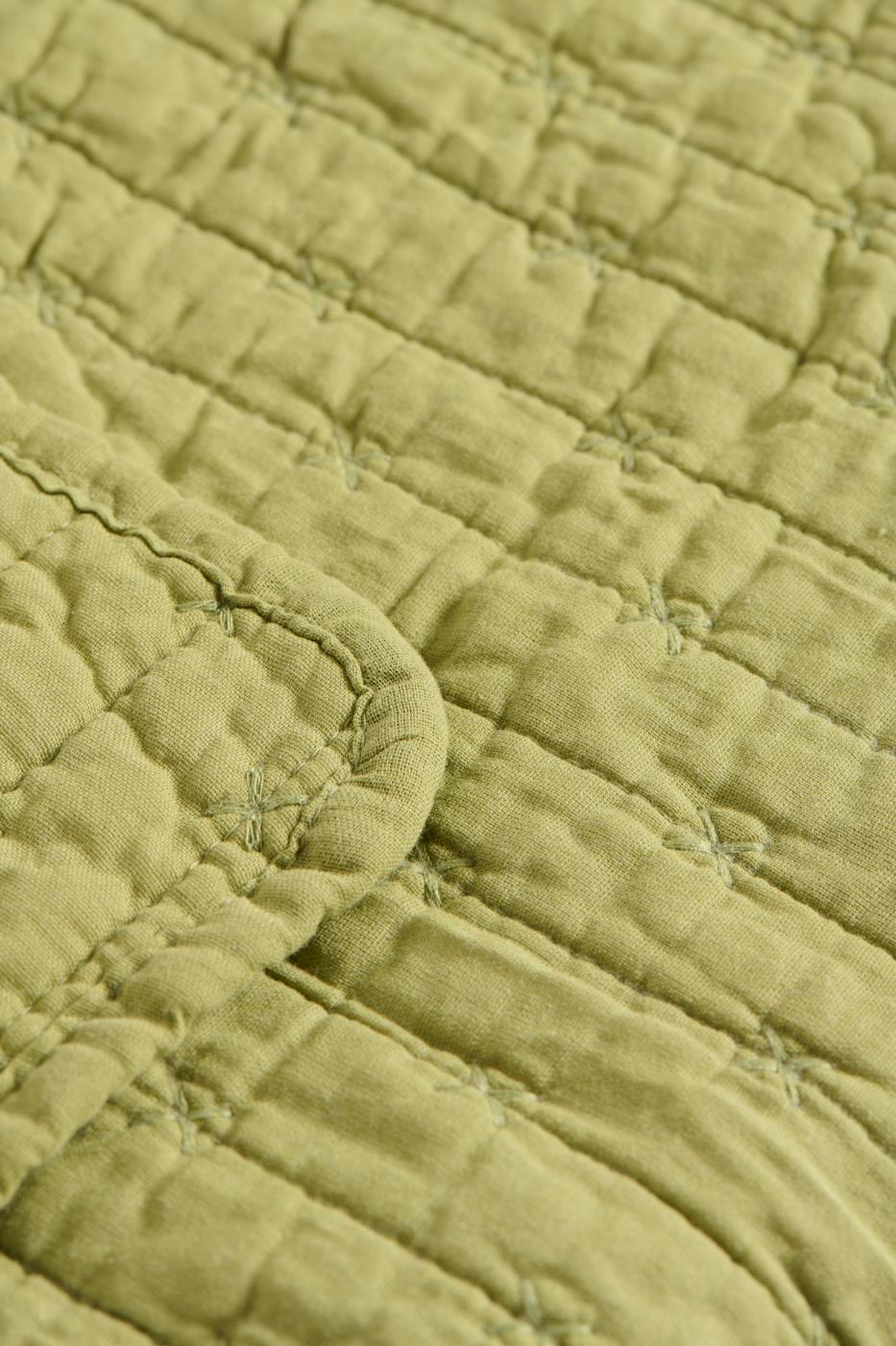 Nahaufnahme der IB Laursen Steppdecke hellgrün mit Kreuzstich-hellgrüner Steppstoff mit sichtbarem Kreuzstich und abgerundeten Kanten, der eine weiche Oberfläche bietet, ideal für skandinavische Wohndeko.