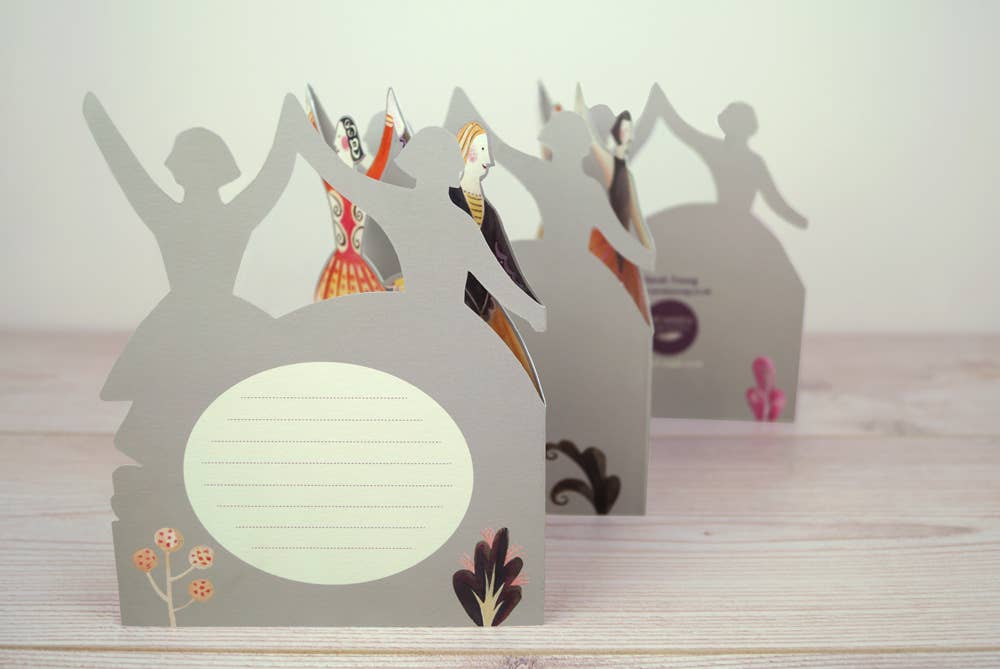 Drei dekorative Tänzer Ausstanzkarten von Sarah Young by Art Angels stehen auf einer hellen Holzoberfläche. Jede Karte hat miteinander verbundene Tänzerinnen, linierte Felder für Notizen und florale Akzente an der Basis - ein charmantes Geschenk für jeden Anlass.