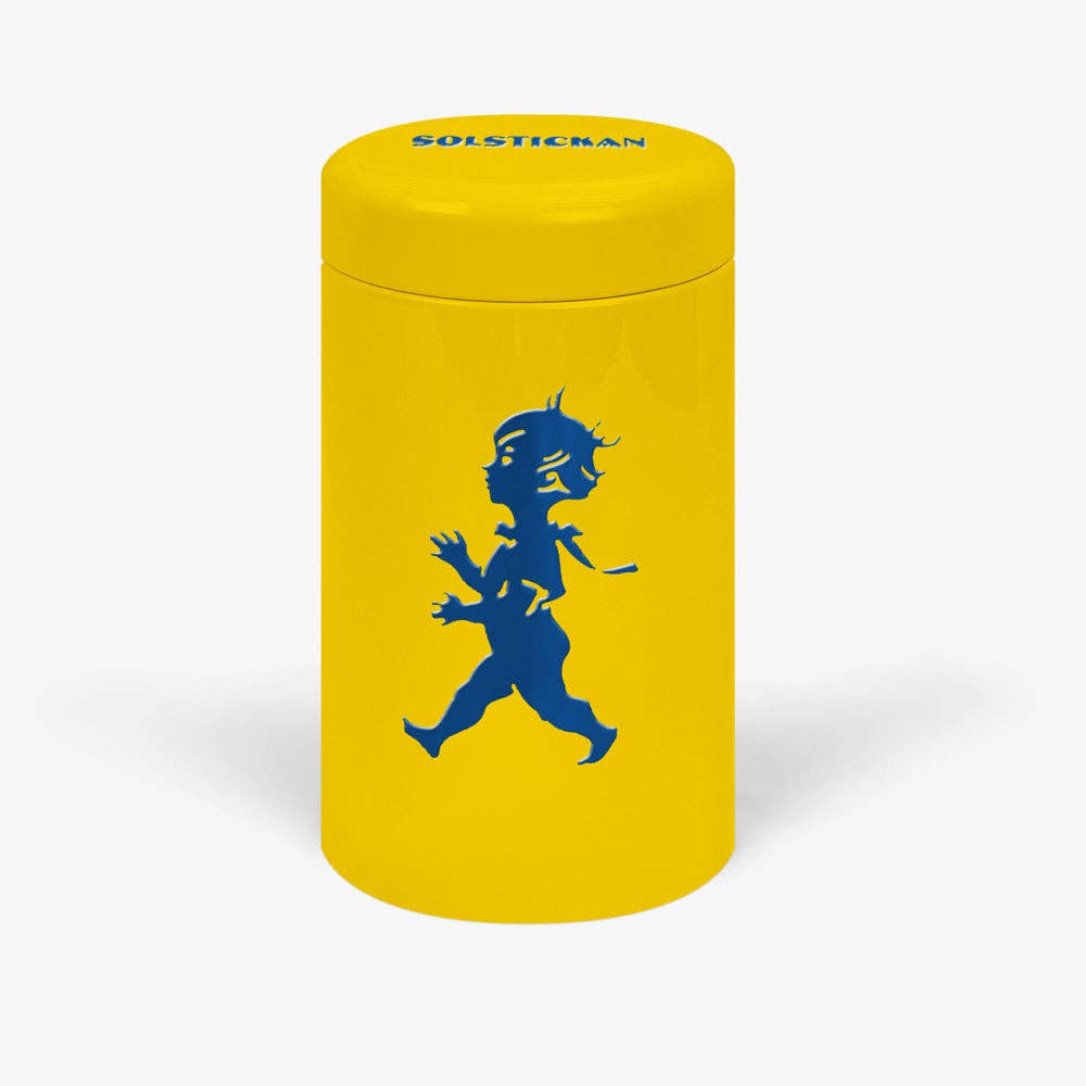 Die Solstickan Design - Streichholzröhre in Gelb/Blau besteht aus einem leuchtend gelben Zylinder mit der blauen Silhouette des Solsticke Boy und dem Schriftzug SOLSTICEMAN" auf dem Deckel und erinnert an das klassische Streichholz aus Blech.