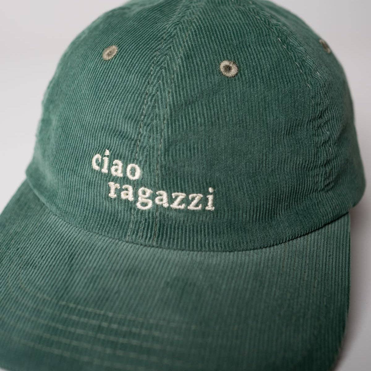 Die arrel responsible apparel | Ciao ragazzi Premium Cord Dad Cap in grün & creme aus Bio-Baumwolle trägt auf der Vorderseite den Schriftzug "ciao ragazzi" in weiß gestickt. Diese nachhaltige Kappe wird vor einem schlichten Hintergrund gezeigt.